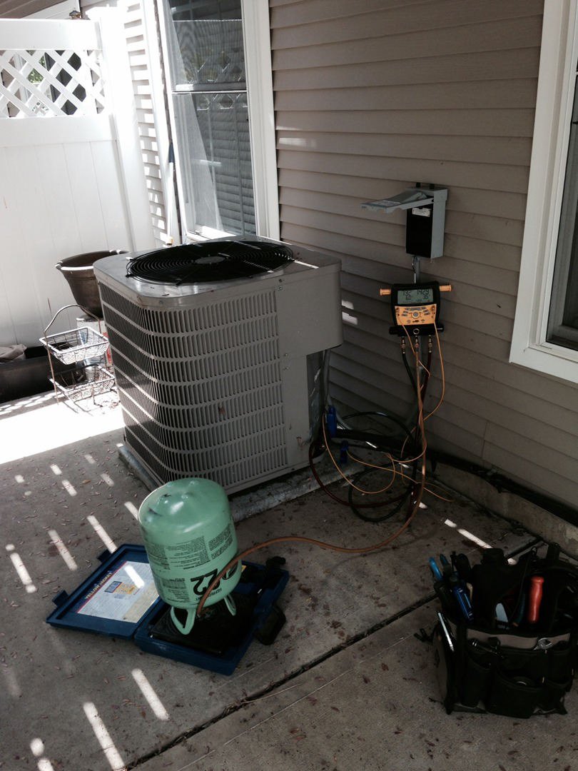 HVAC technician servicing an outdoor condenser unit